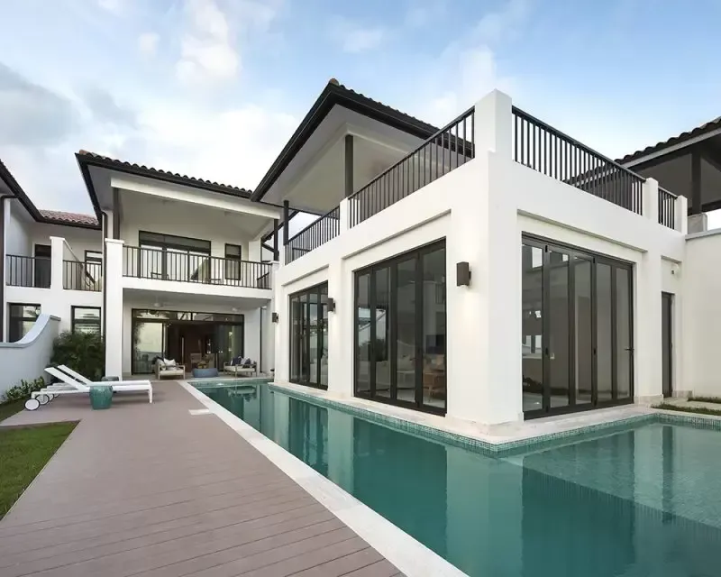 Una gran casa blanca con una piscina delante de ella.