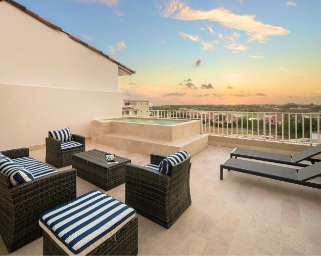 Un patio con muebles de mimbre y una piscina.
