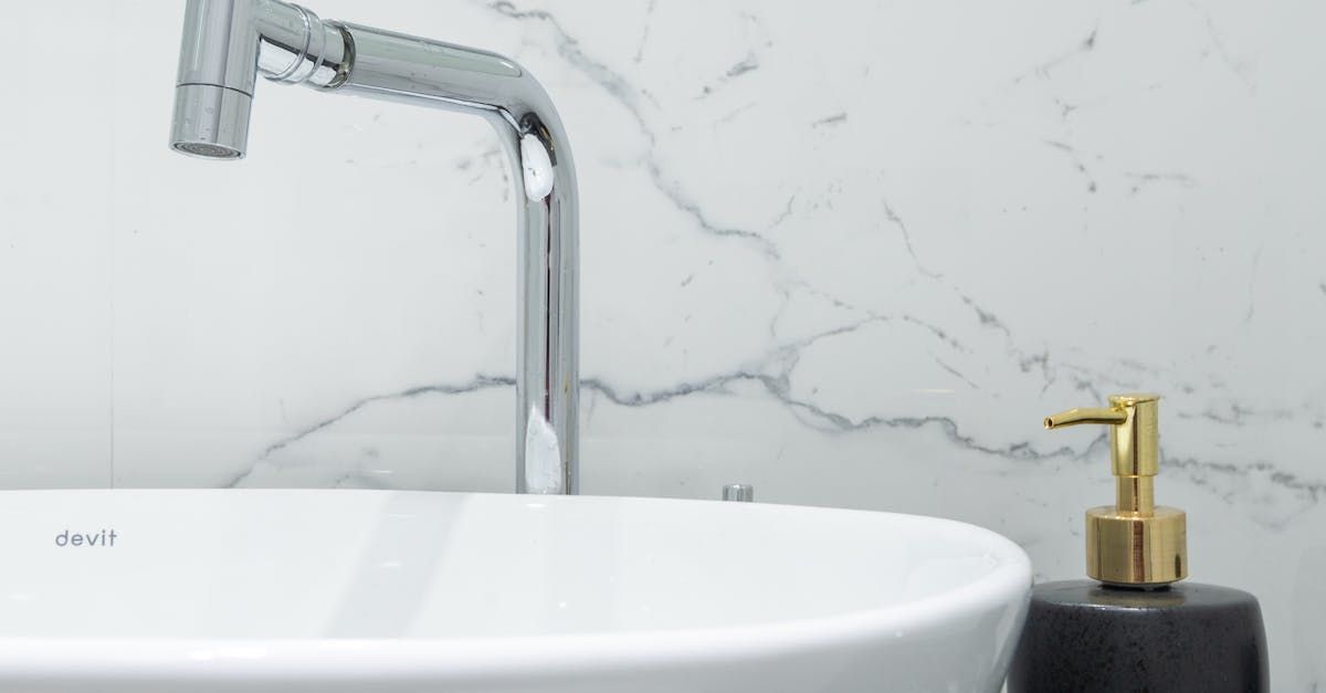 A bathroom sink with a soap dispenser next to it.