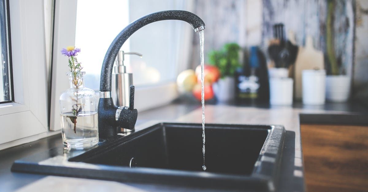 A kitchen sink with water running from the faucet.