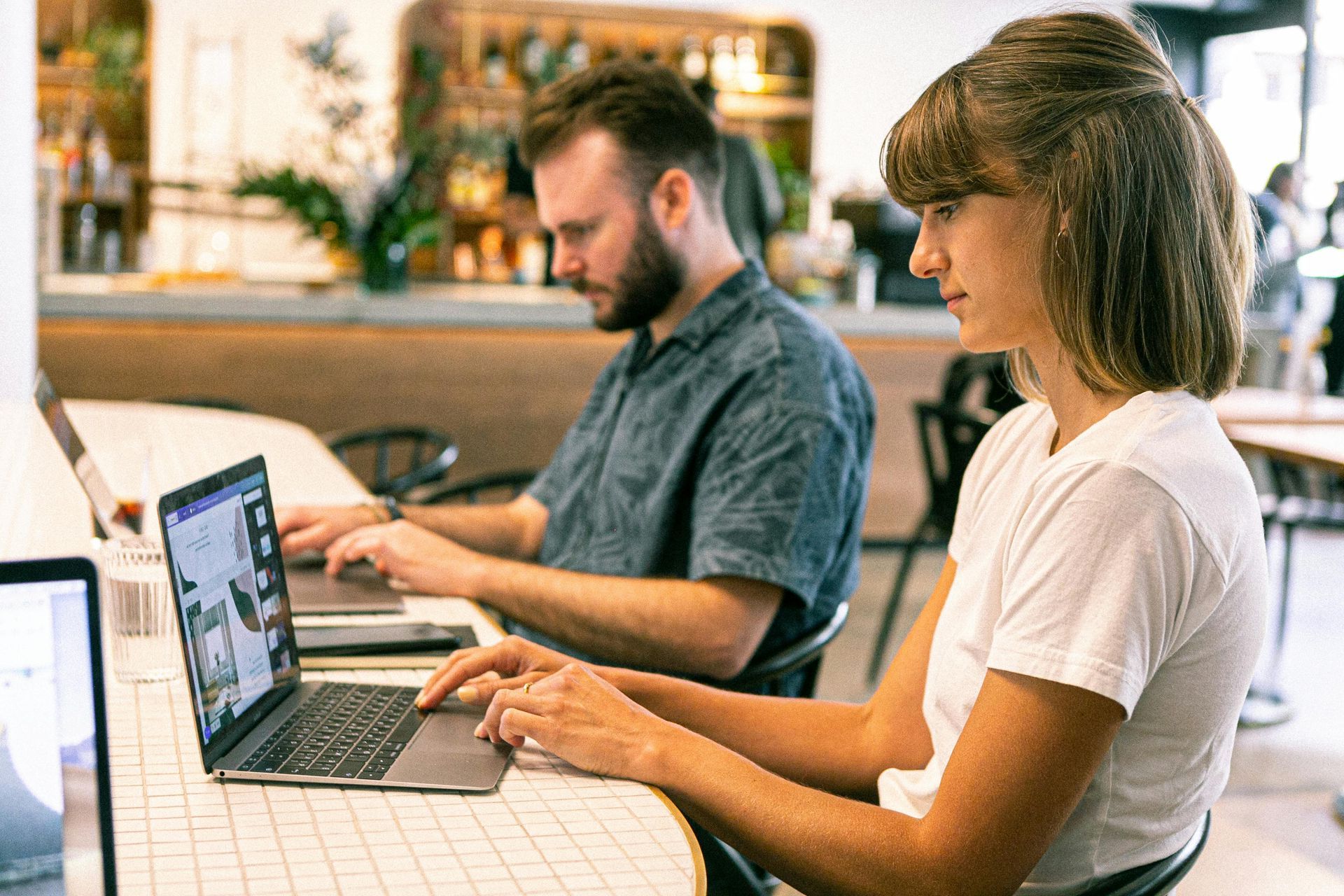 Man and a woman are sitting at a table using laptops to build an effective landing page.