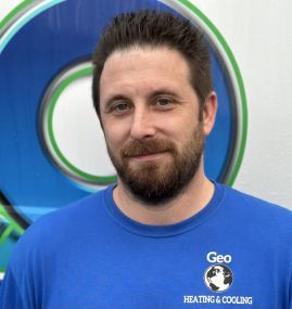 A man with a beard wearing a blue geo heating and cooling shirt