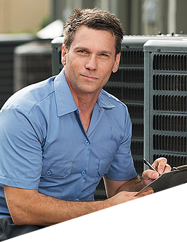 A man in a blue shirt is writing on a clipboard in front of an air conditioner.