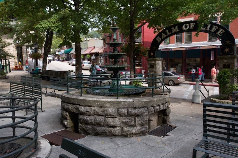 A park with a fountain and a sign that says balm of life