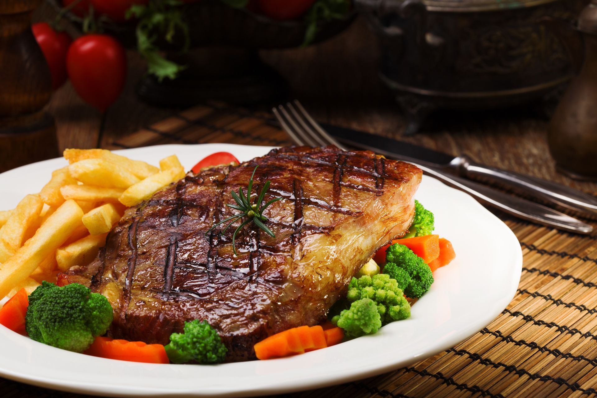 A white plate topped with a steak and french fries