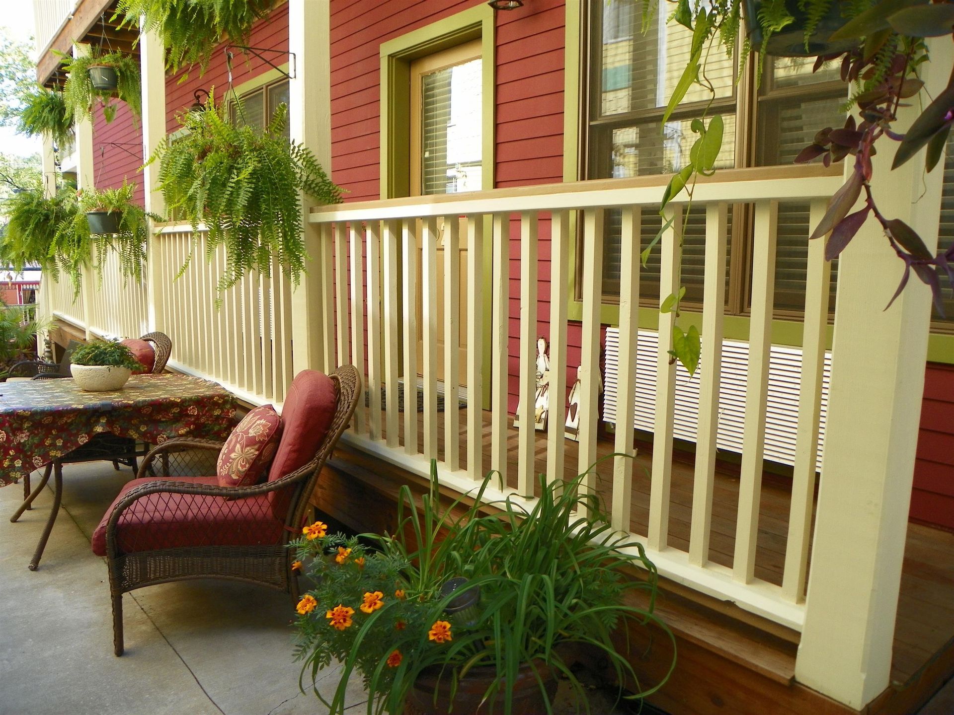 A red house with a porch with a table and chairs