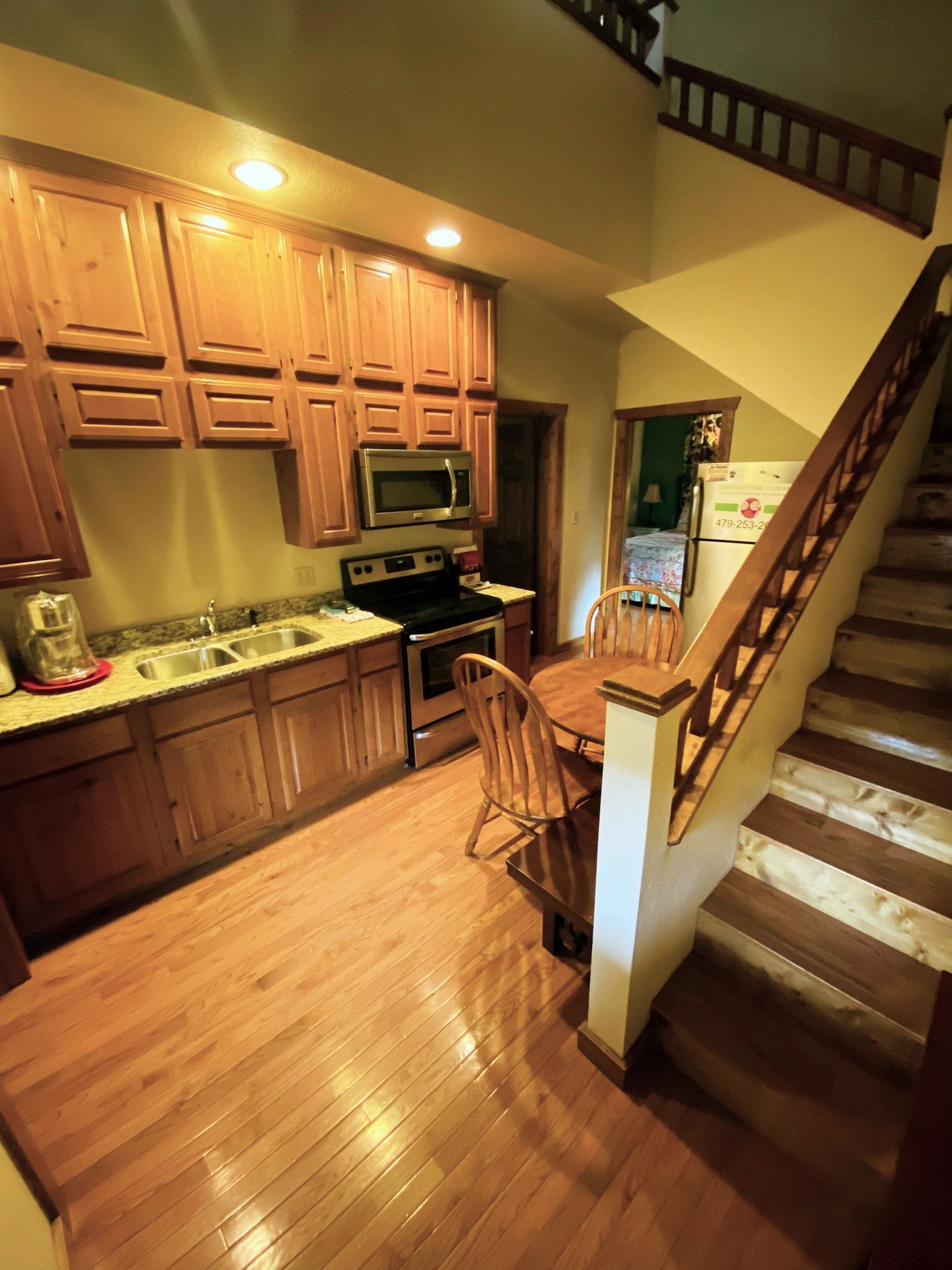 A kitchen with a staircase leading up to the second floor