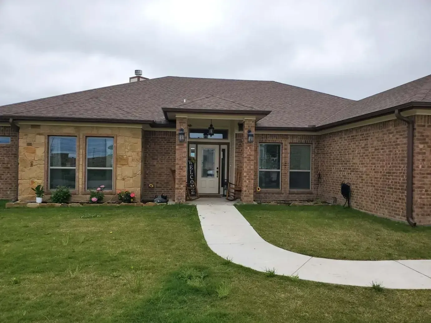 A large brick house with a walkway leading to the front door.