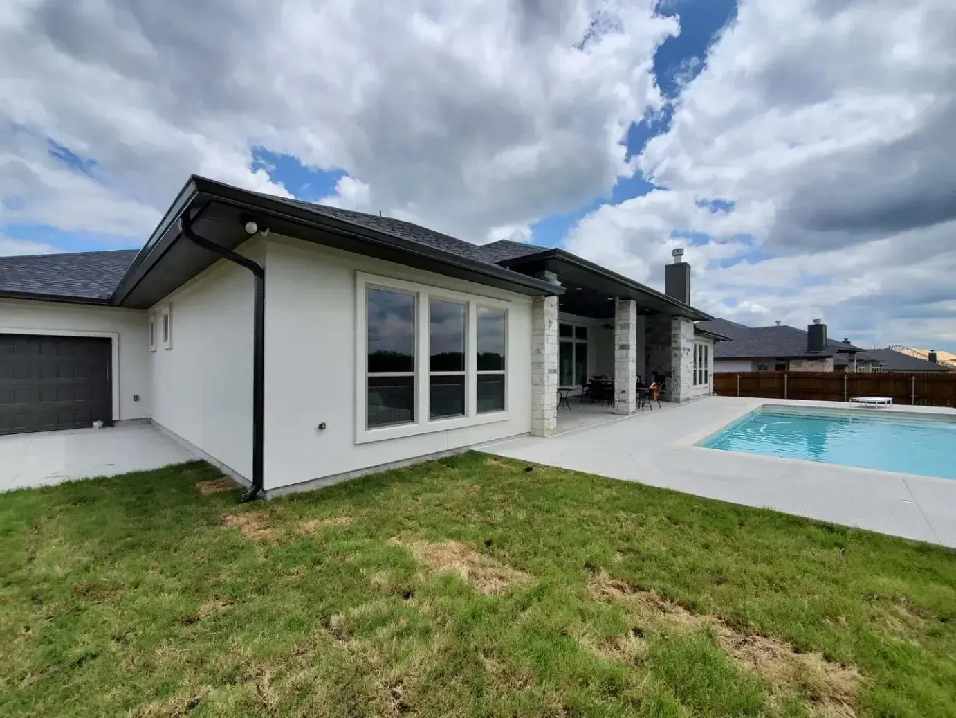 A white house with a swimming pool in the backyard.