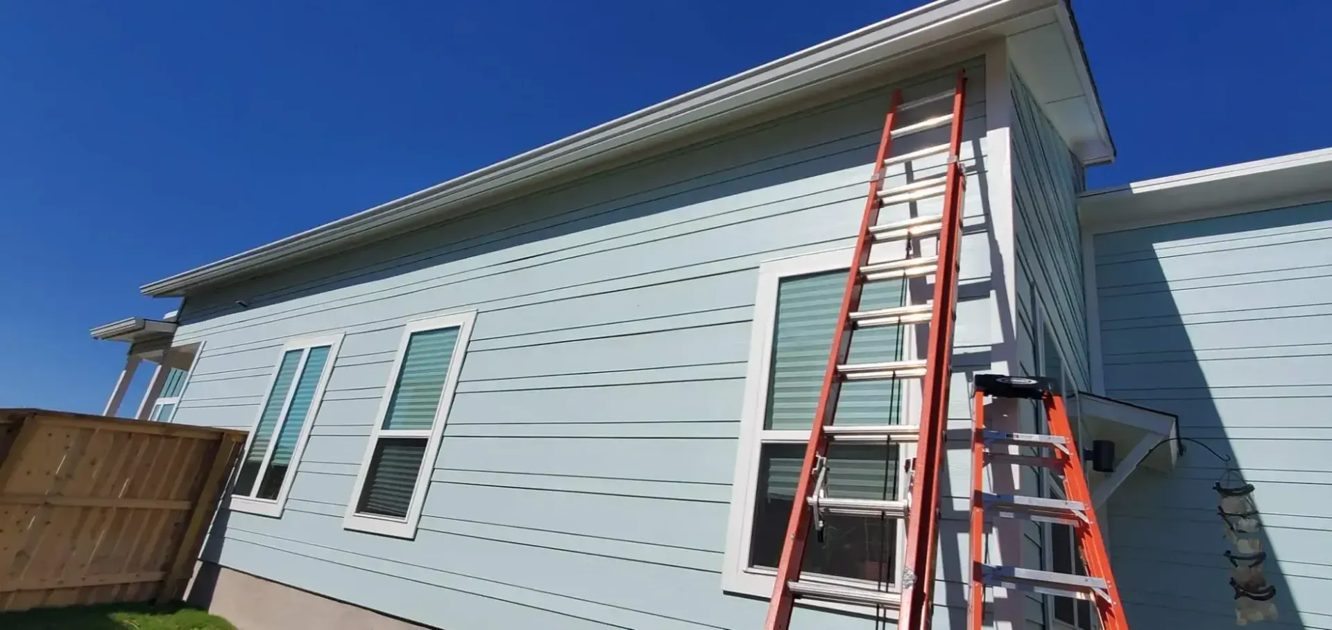 A ladder is sitting on the side of a house.