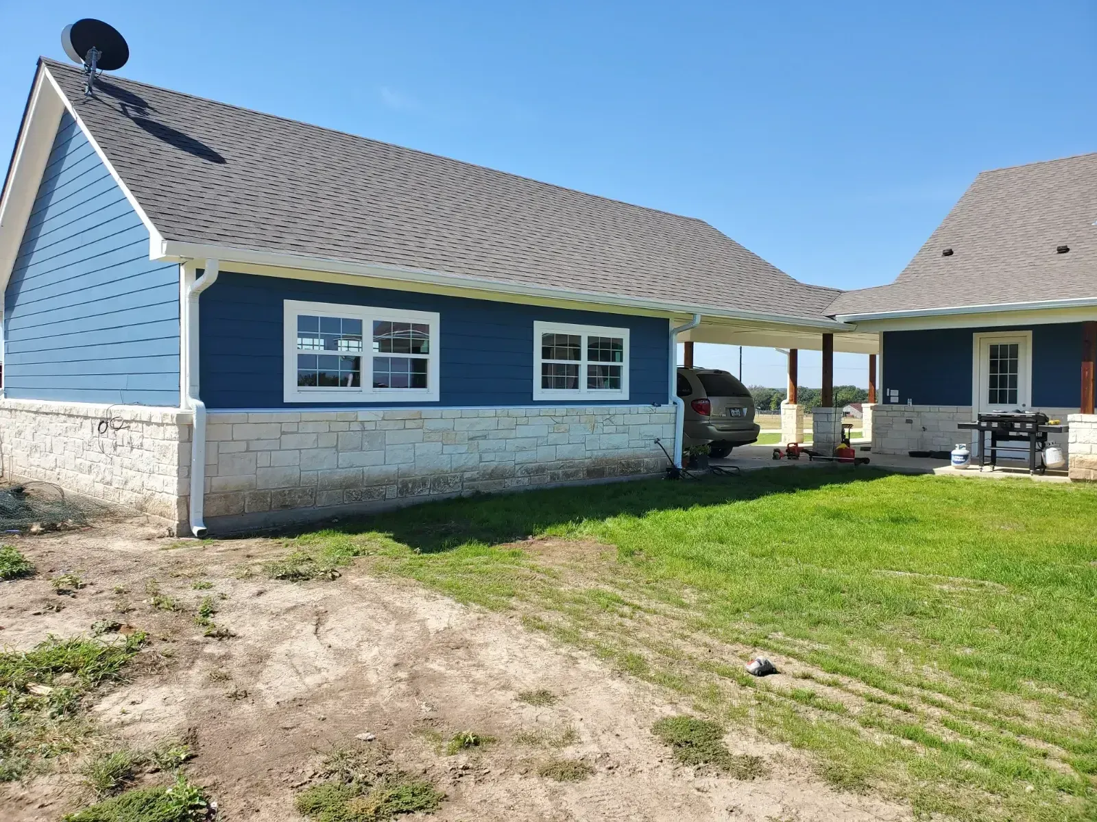 A blue house with a car parked in front of it.