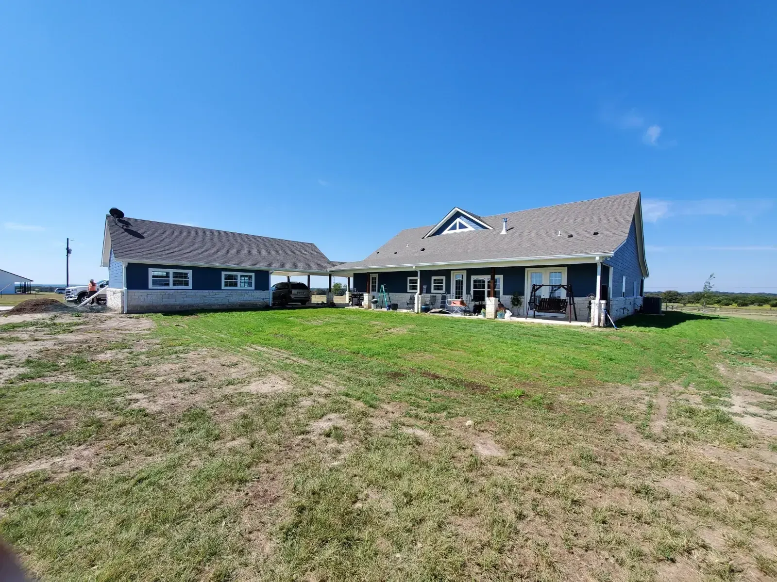 A large house is sitting on top of a lush green field.