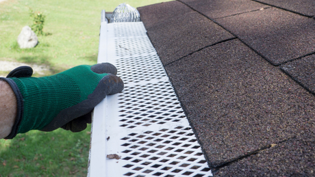 The Right Color – Modern kitchen with island, cooktop, white cabinets, colorful backsplash, and bright lighting.