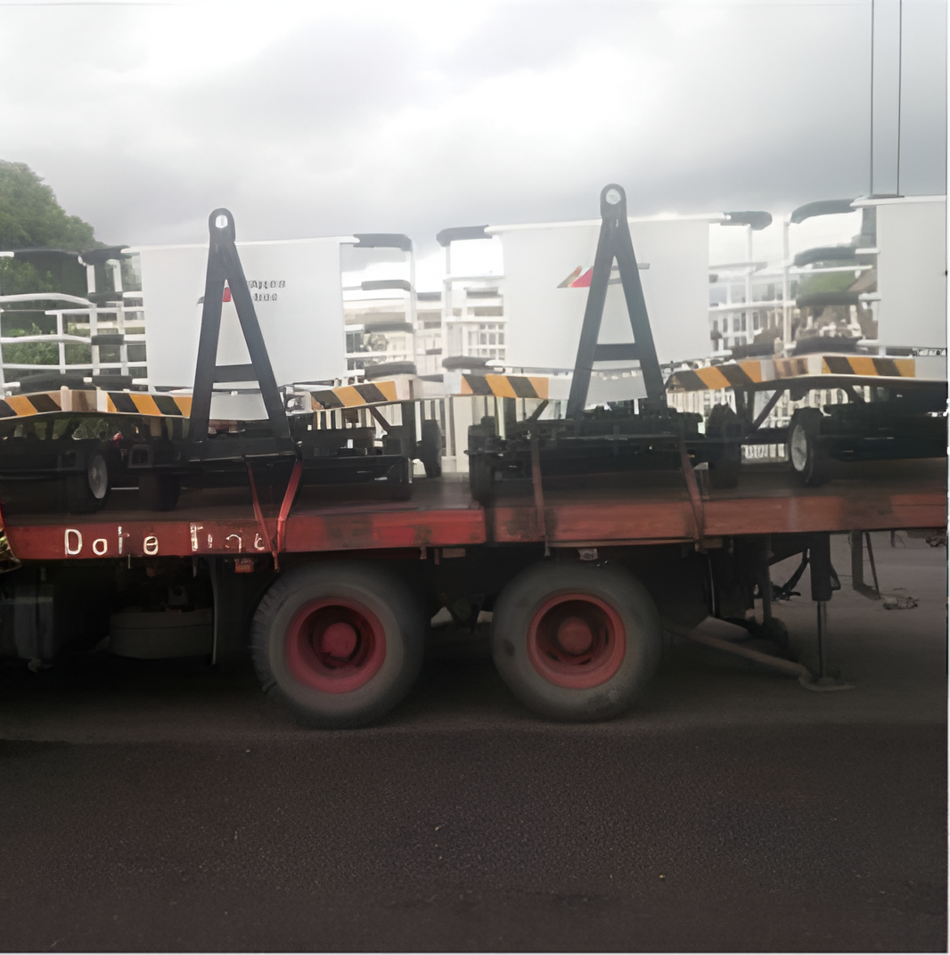 Flatbed Truck Carrying White Containers, Black Frames, and Red Wheels on A Road — Kerubin Logistics Inc in the Philippines