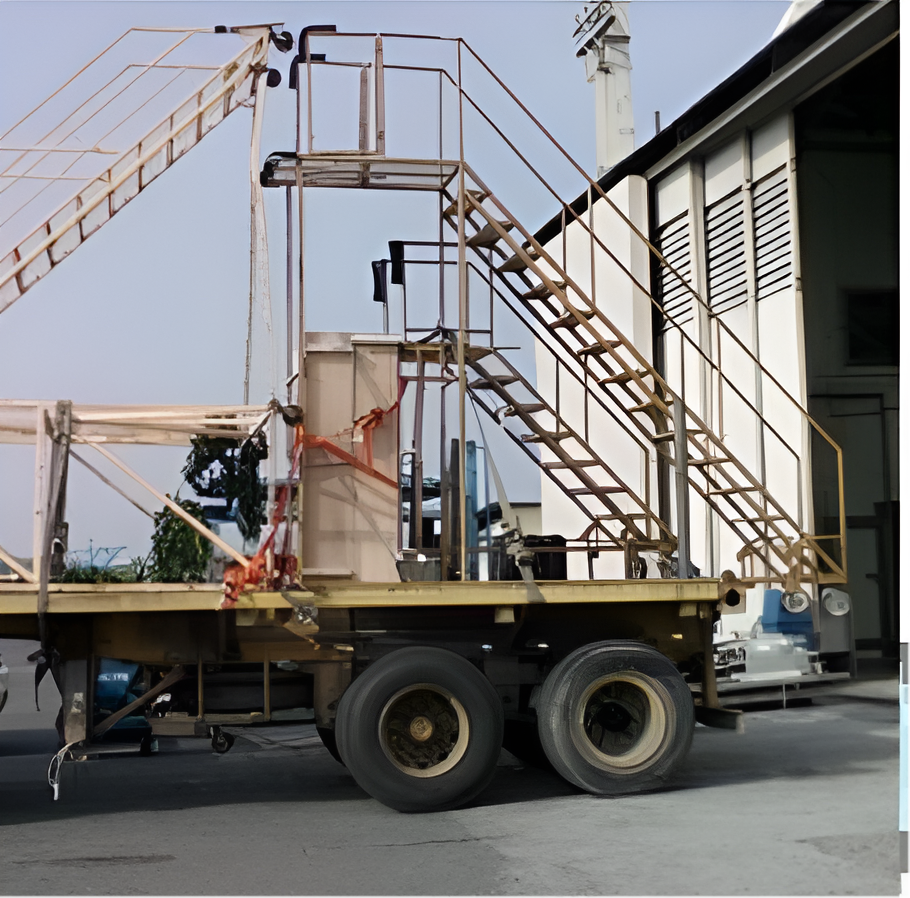 Yellow Industrial Trailer with Multiple Stairways and A Tower Next to A Building — Kerubin Logistics Inc in the Philippines
