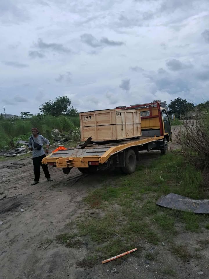 Man standing Near a Flatbed Truck Carrying a Wooden Crate on A Dirt Road — Kerubin Logistics Inc in the Philippines