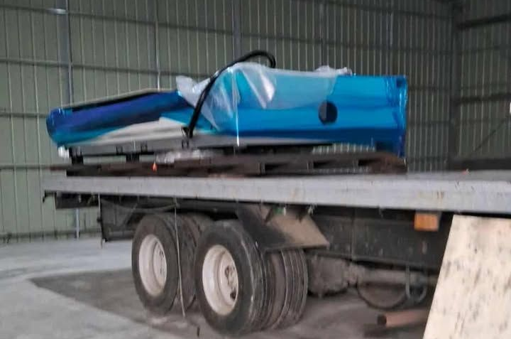 Blue-wrapped Equipment on A Flatbed Truck Inside a Building — Kerubin Logistics Inc in the Philippines