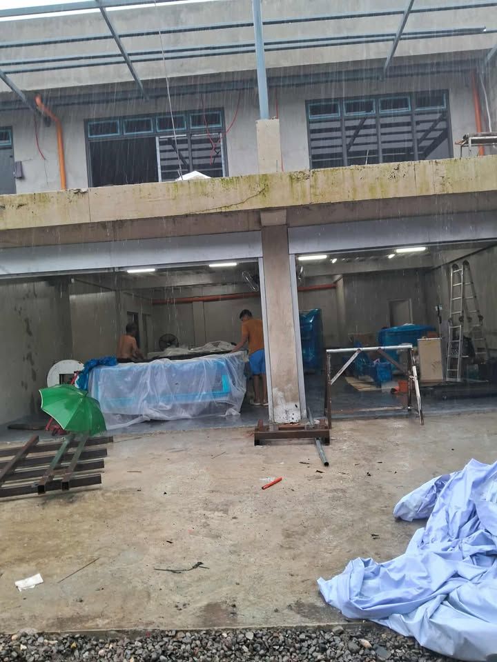 Construction Site with Workers, Building, and Materials, Possibly During Rain — Kerubin Logistics Inc in the Philippines