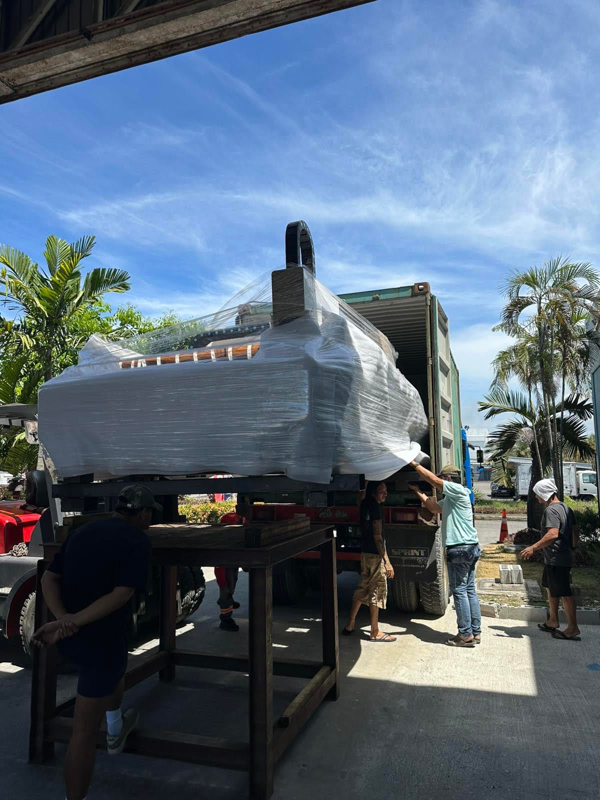 Workers Loading a Large, Wrapped Object onto A Truck in A Sunny Outdoor Setting — Kerubin Logistics Inc in the Philippines