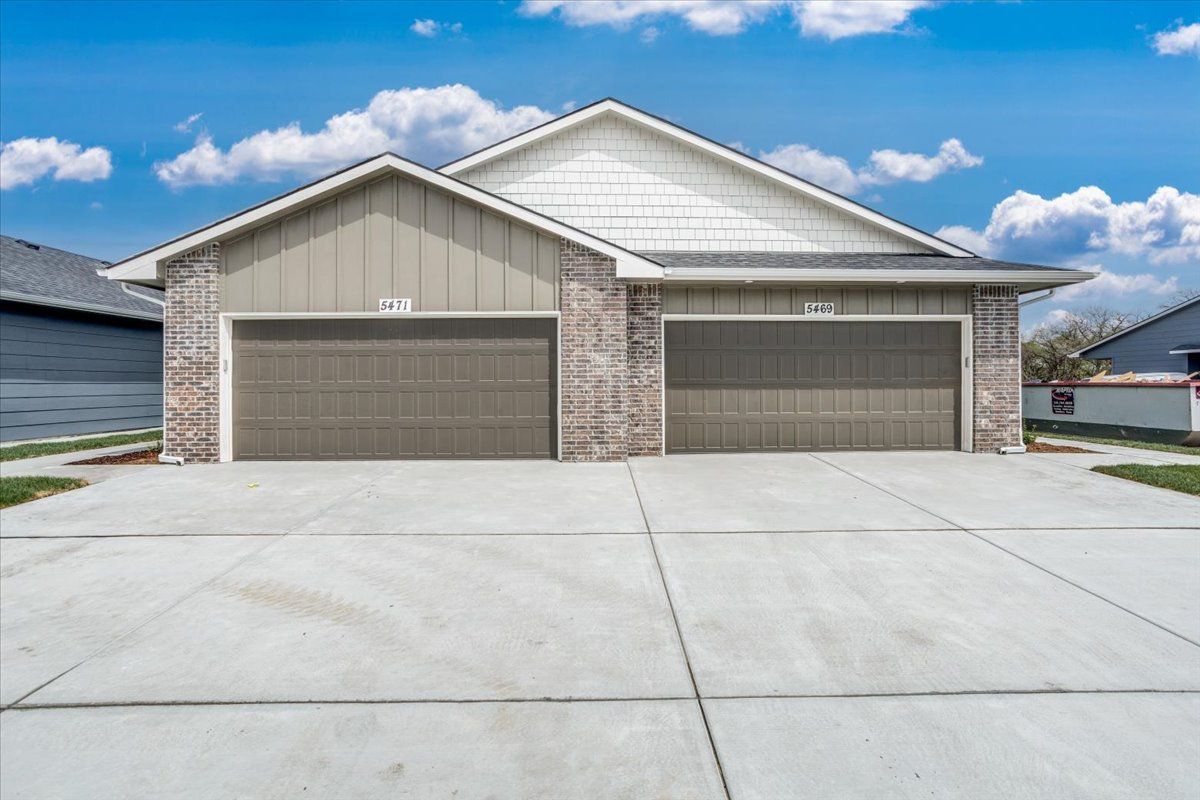 A house with two garage doors and a concrete driveway.