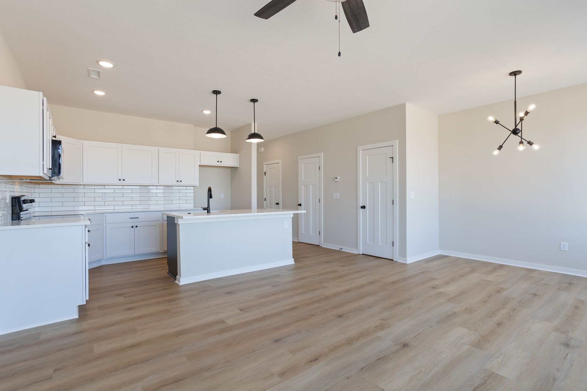 There is a ceiling fan in the kitchen and a ceiling fan in the living room.