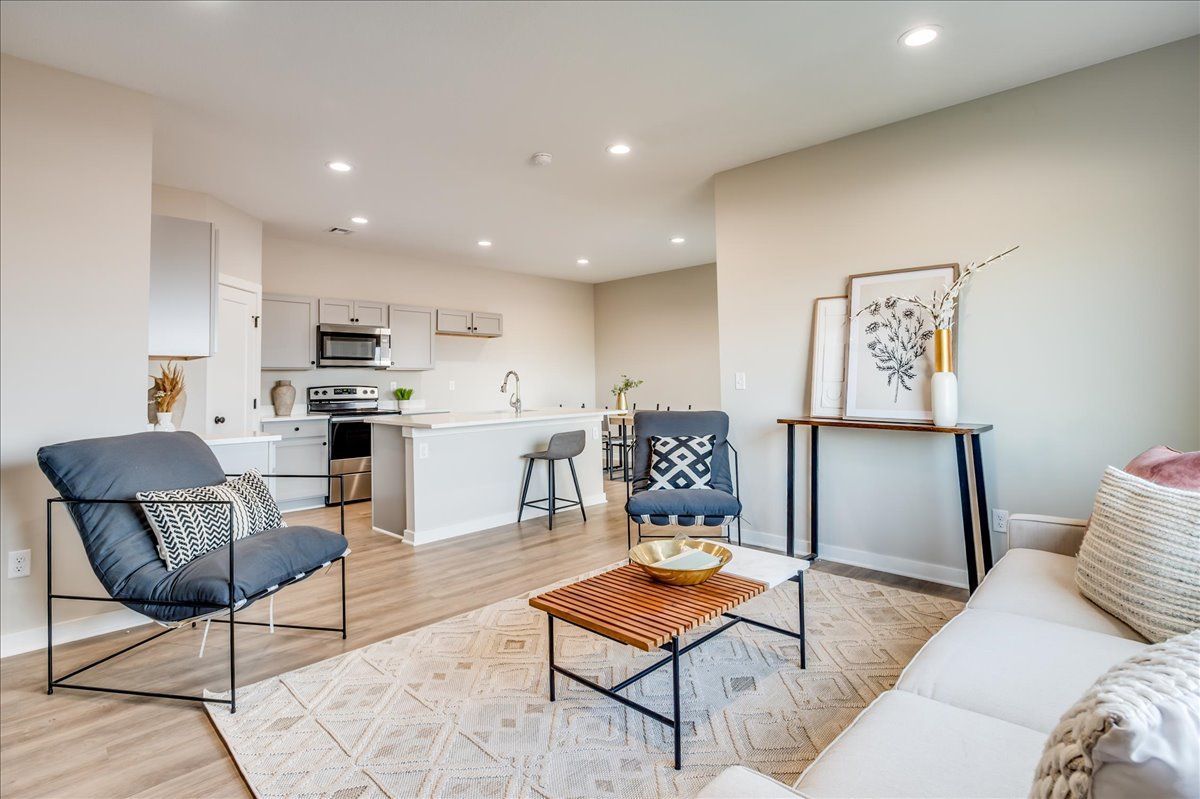 A living room with a couch , chairs , and a coffee table.