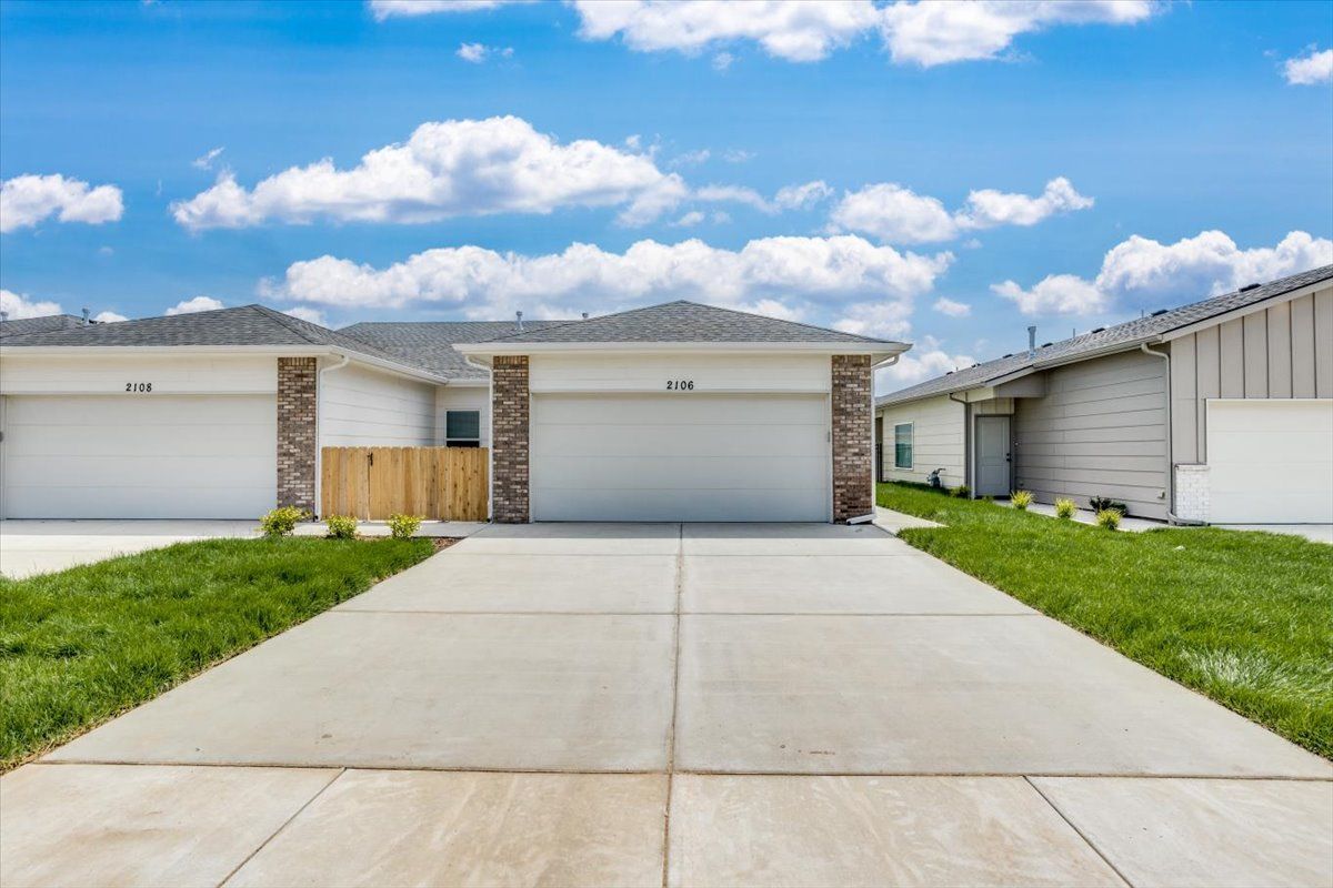 A driveway leading to a house with two garages.