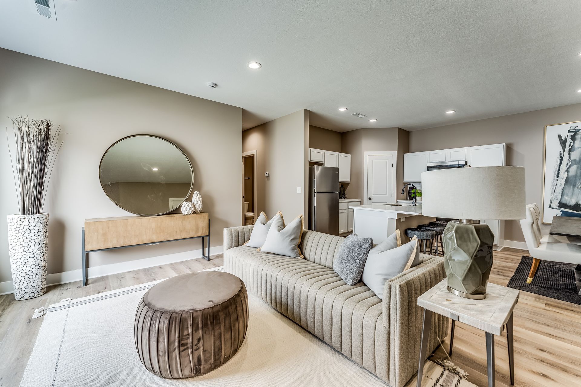A living room with a couch , coffee table , and mirror.