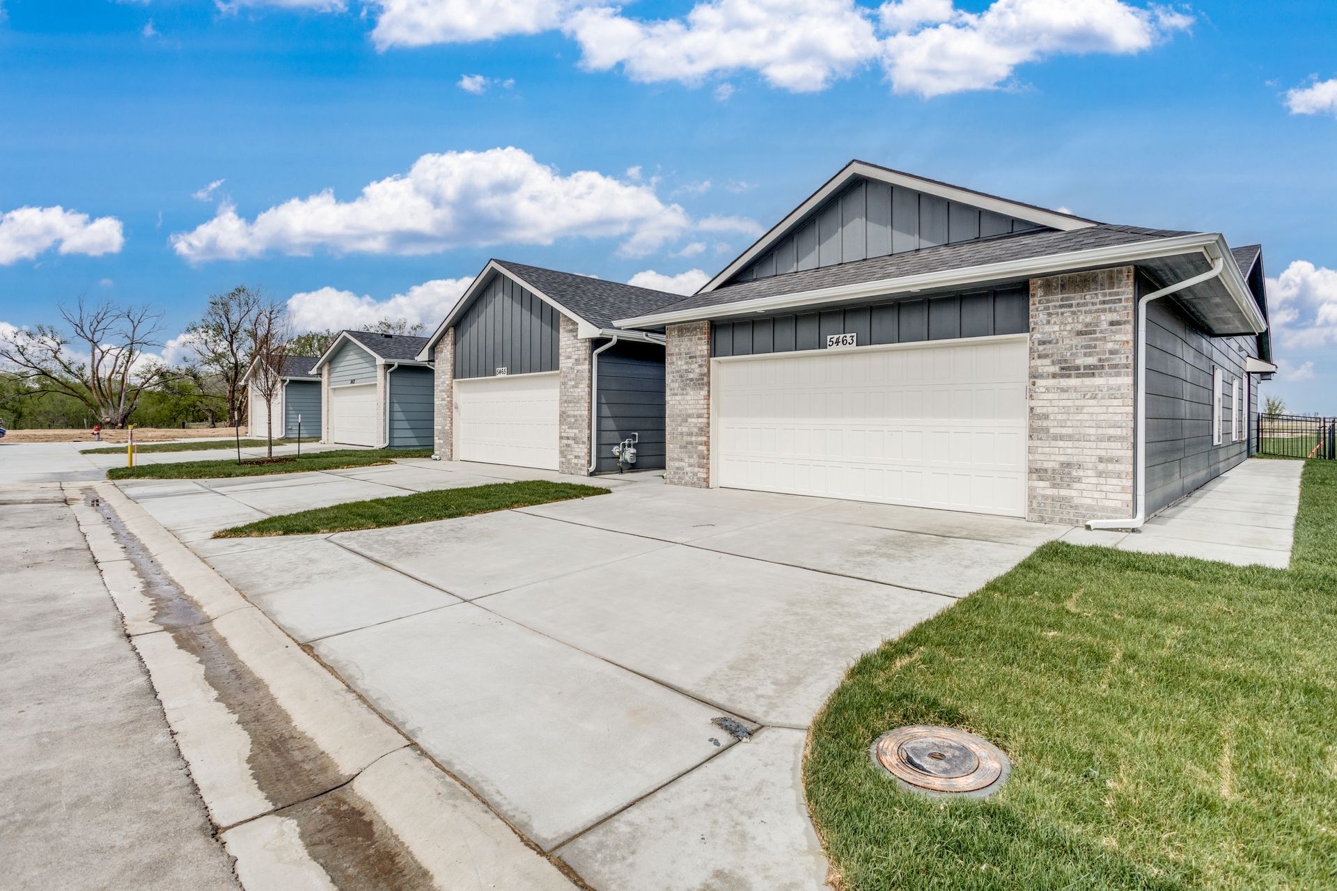 A house with two garages and a concrete driveway in a residential area.