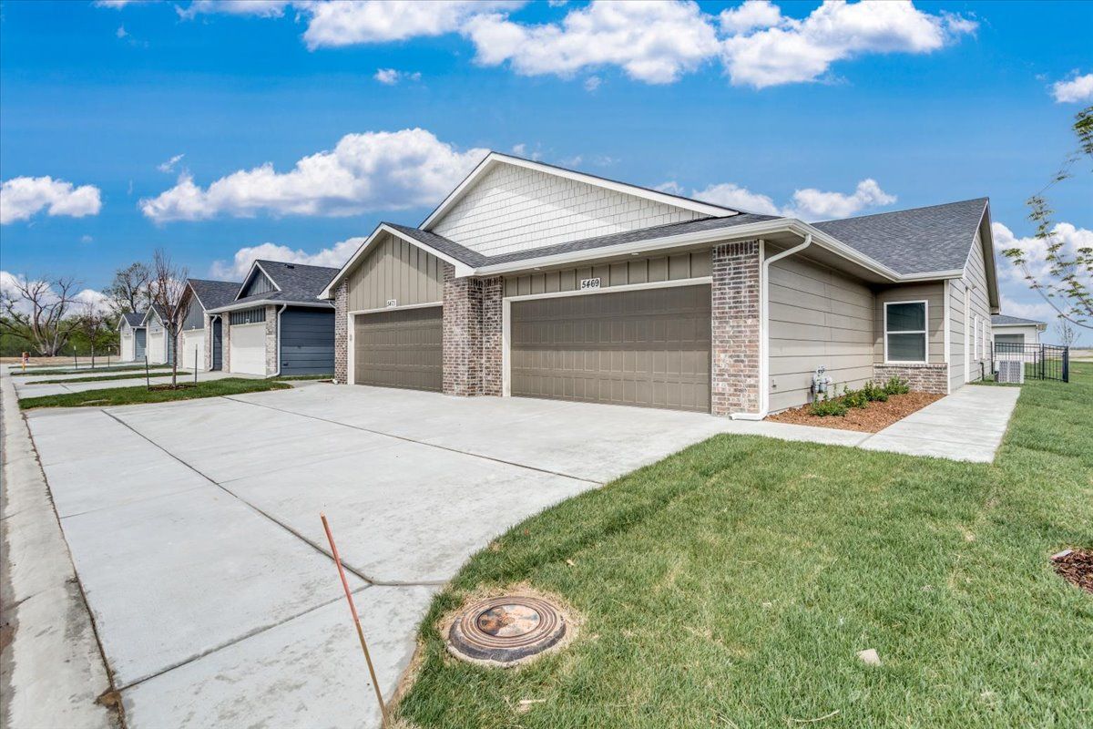 A house with two garages and a concrete driveway.