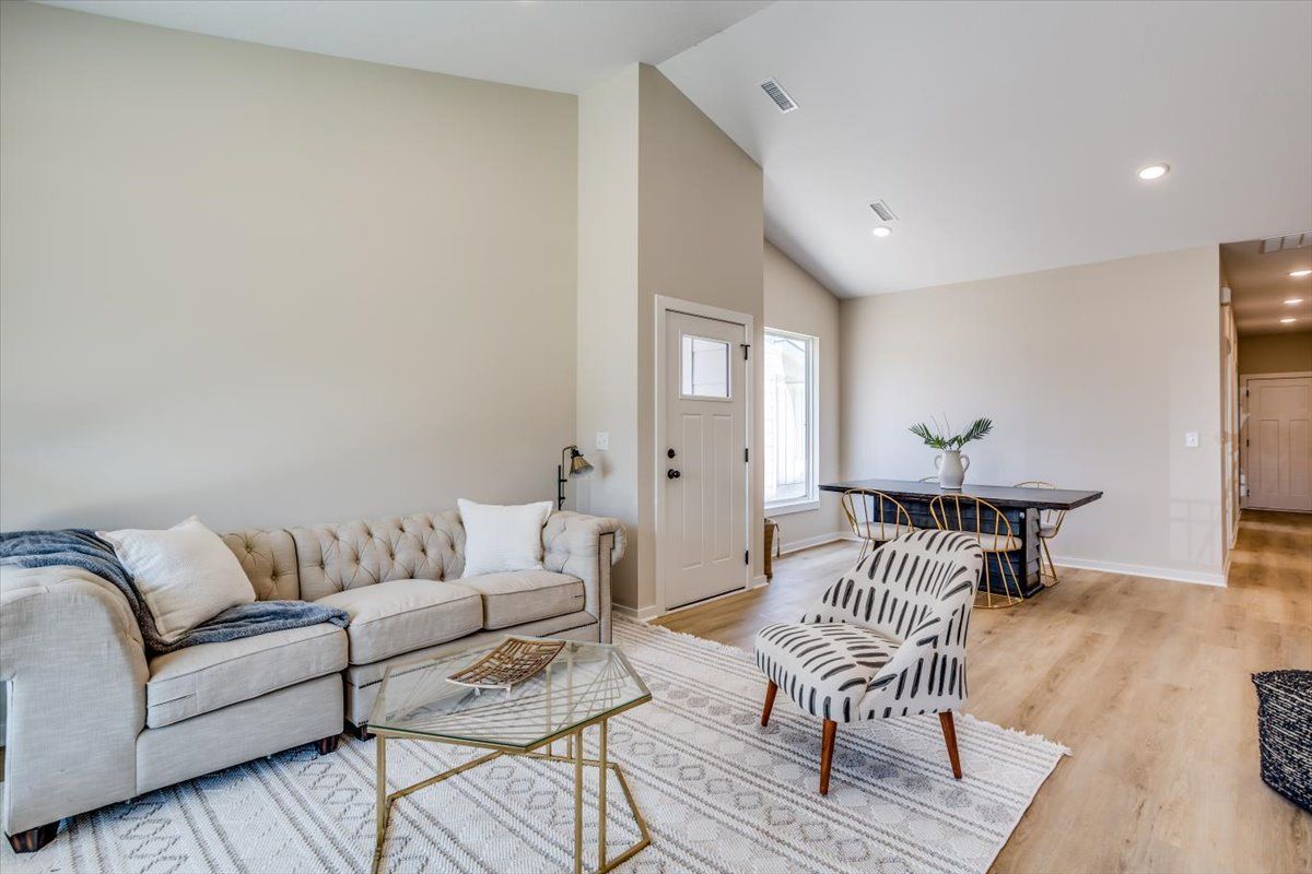 A living room with a couch , chair , table and rug.