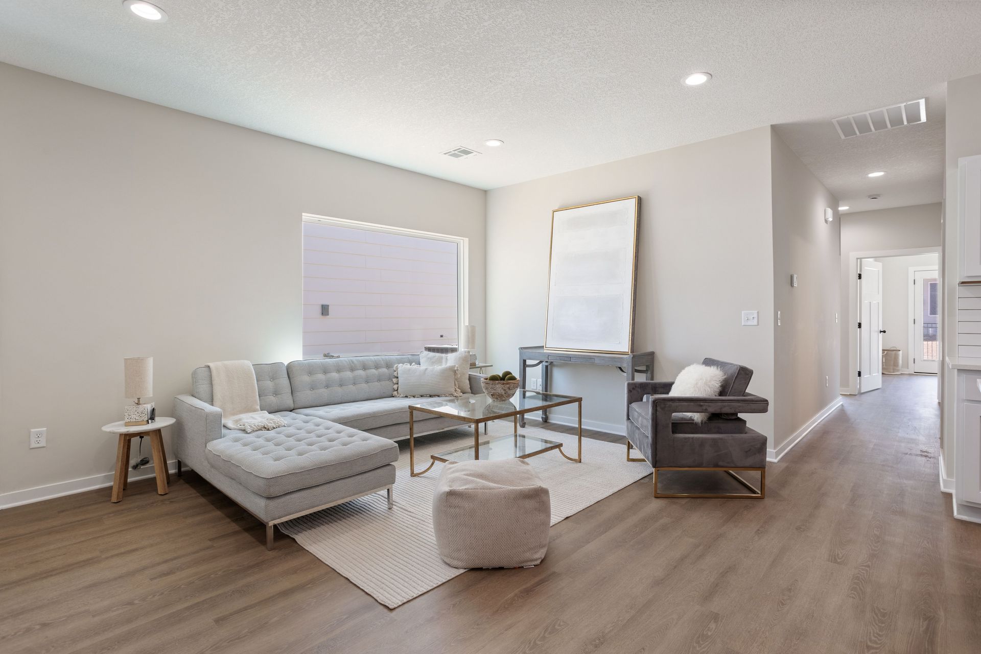 A living room with a couch , chair , coffee table and rug.