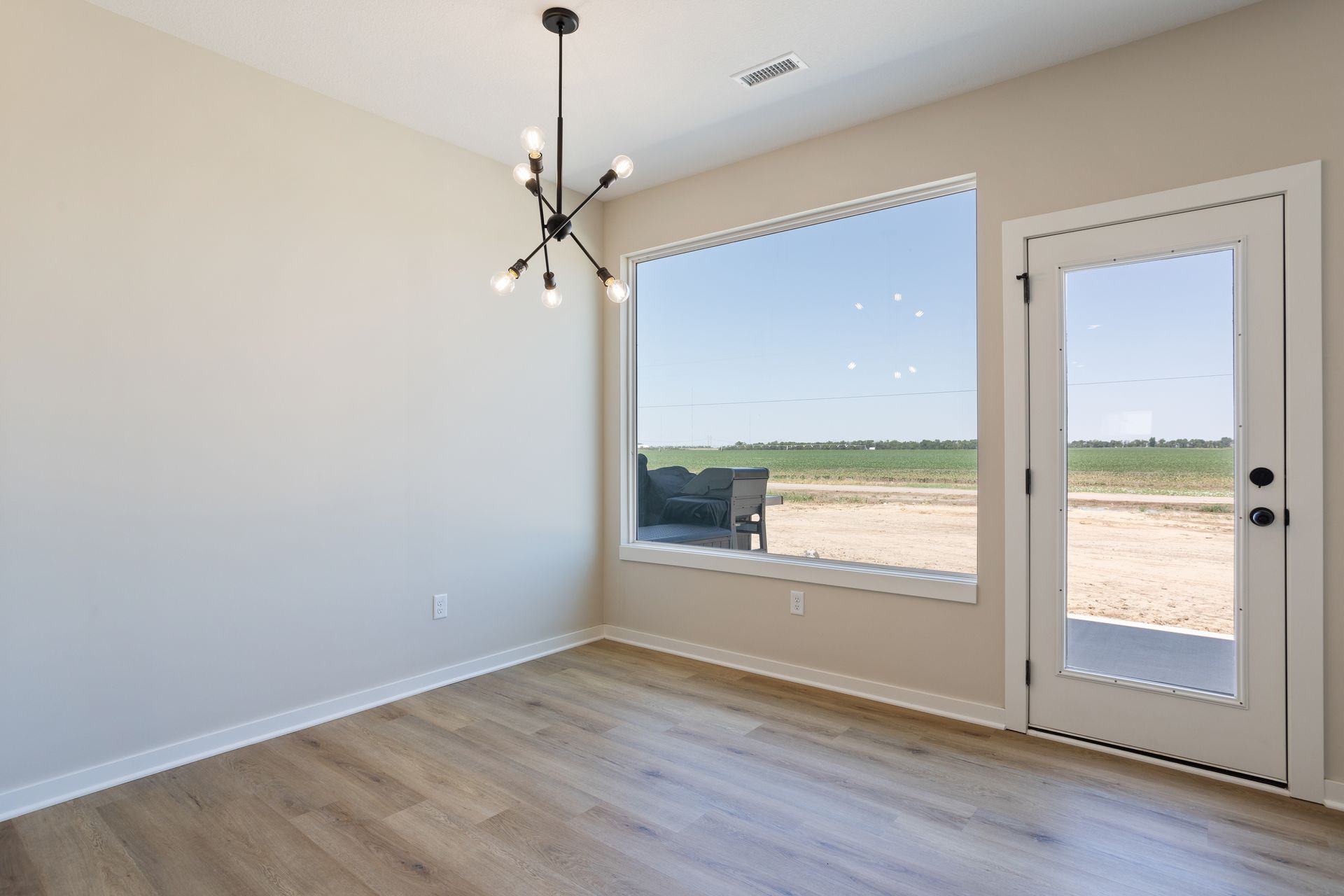 An empty room with a large window and a door.
