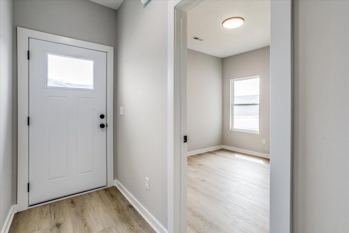 A hallway with a door and a window in a house.