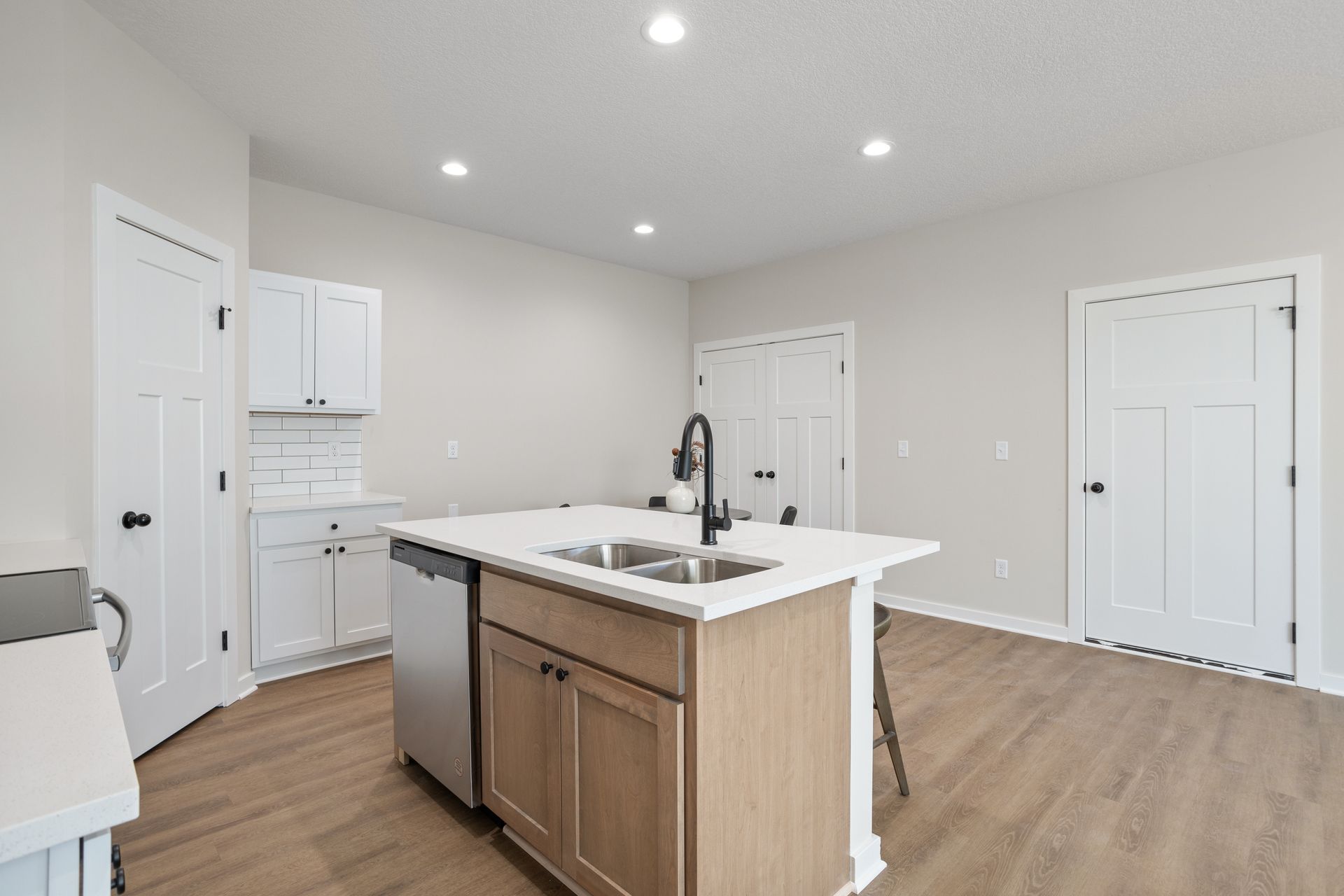 A kitchen with a large island , sink , and dishwasher.