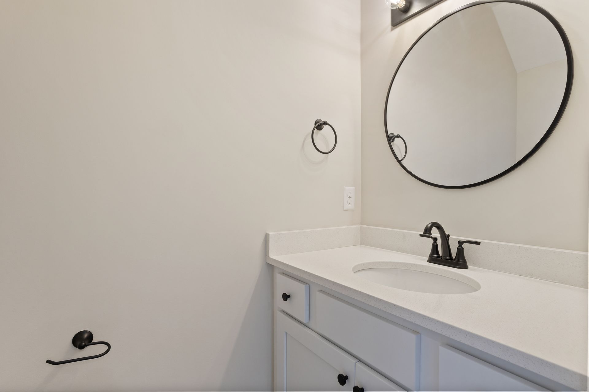 A bathroom with a sink , mirror and towel rack.