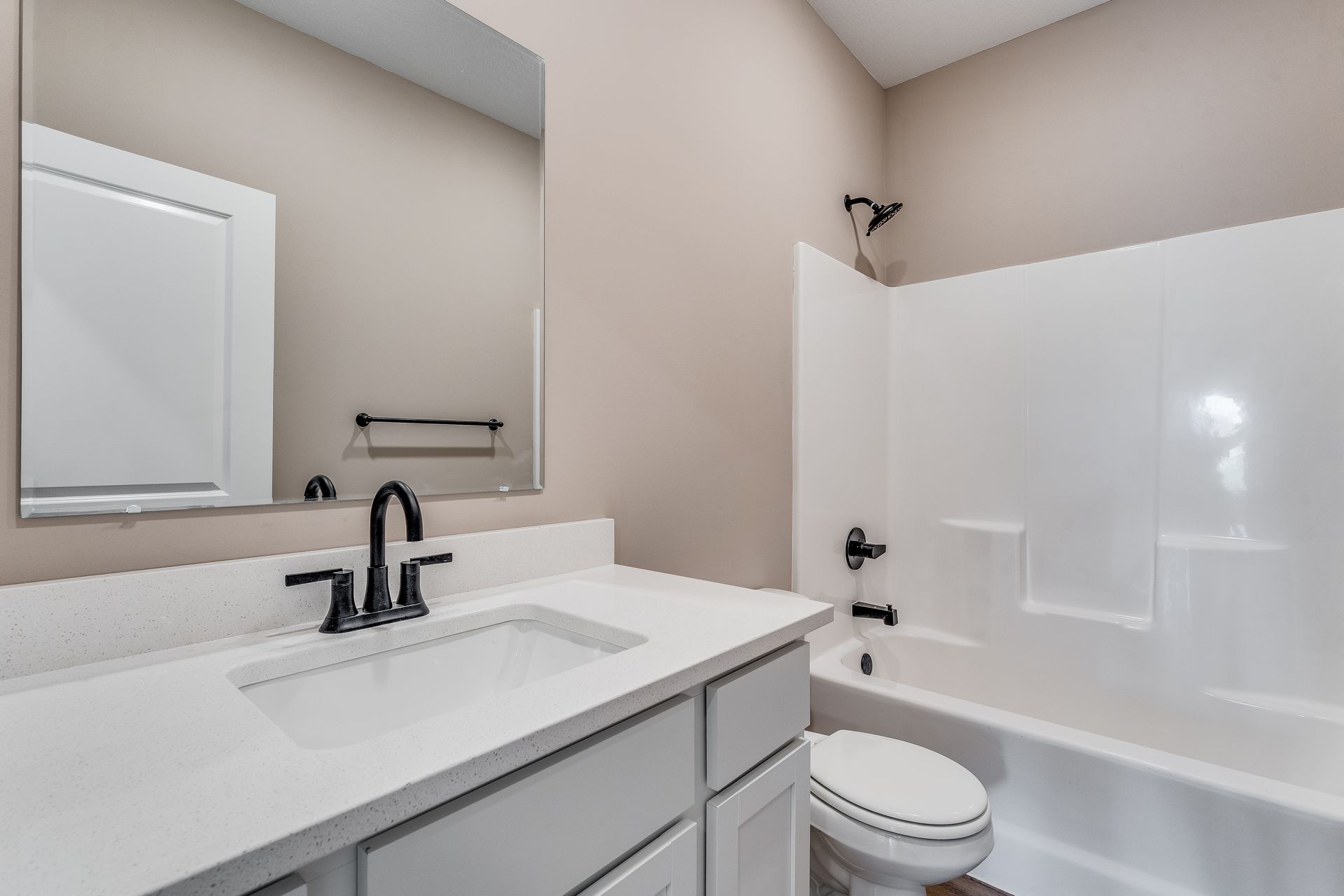 A bathroom with a sink , toilet , tub and mirror.