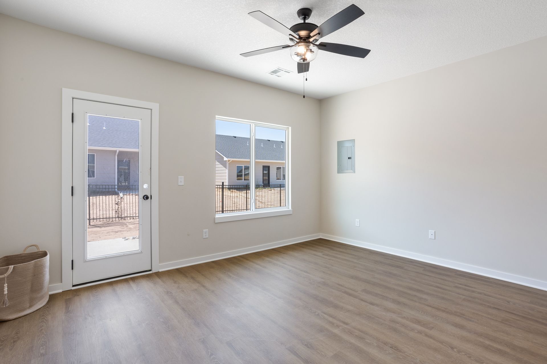 An empty living room with hardwood floors and a ceiling fan.