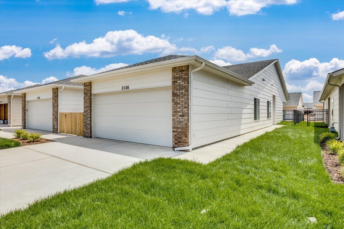 A white house with two garages in a residential area.
