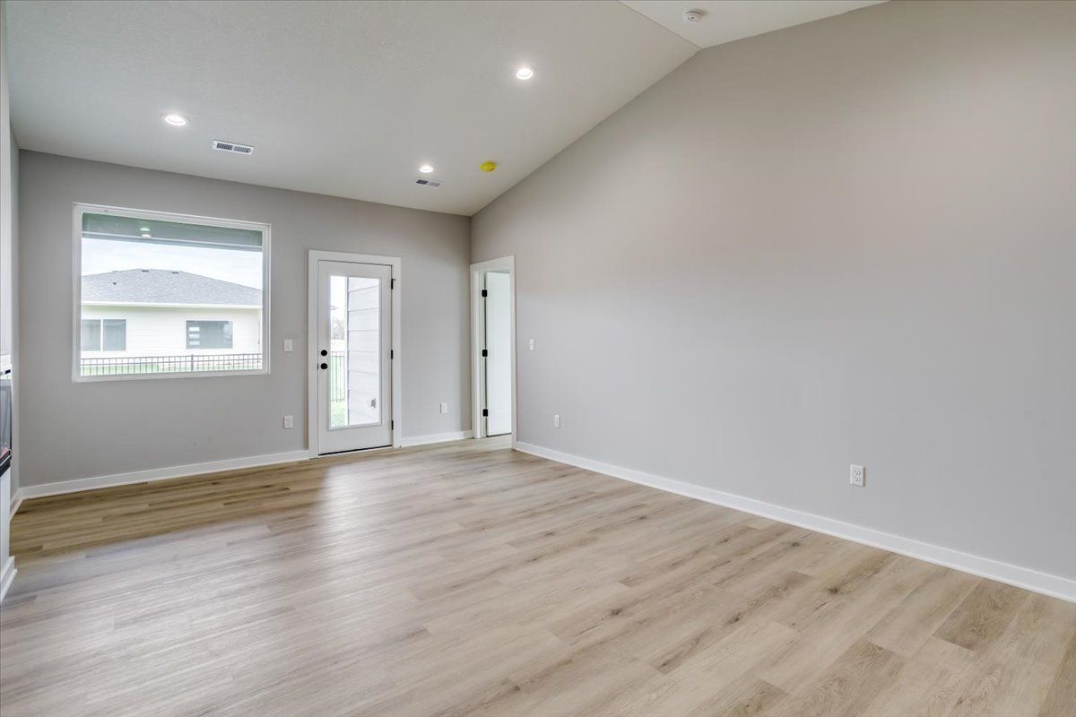 An empty living room with hardwood floors and a window.