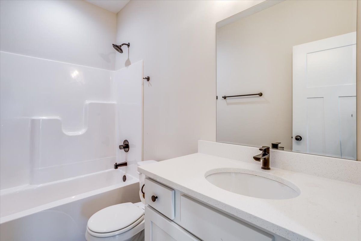 A bathroom with a sink , toilet , bathtub and mirror.