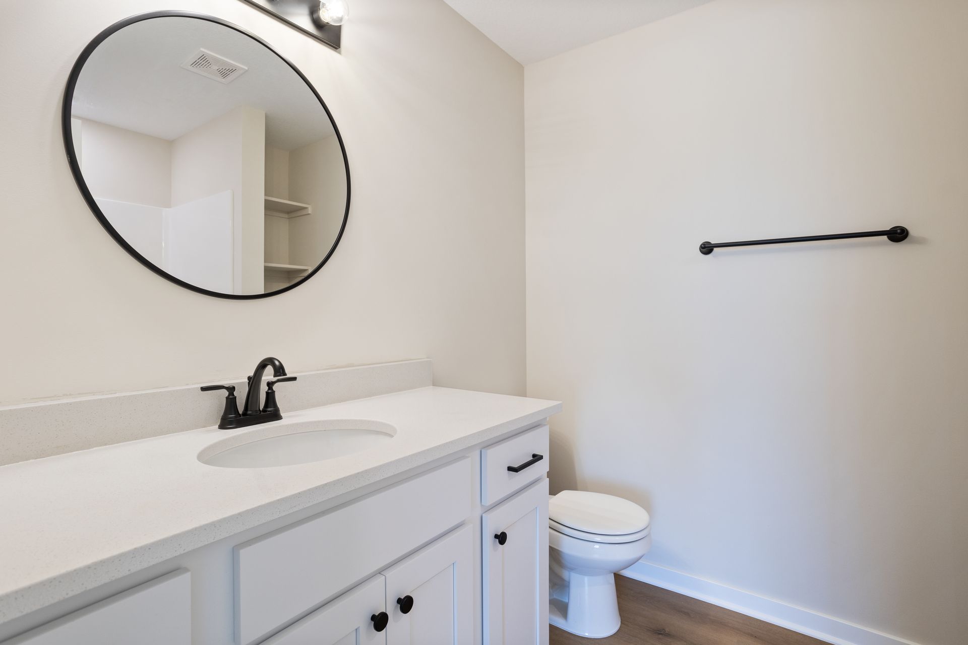 A bathroom with a sink , toilet and mirror.