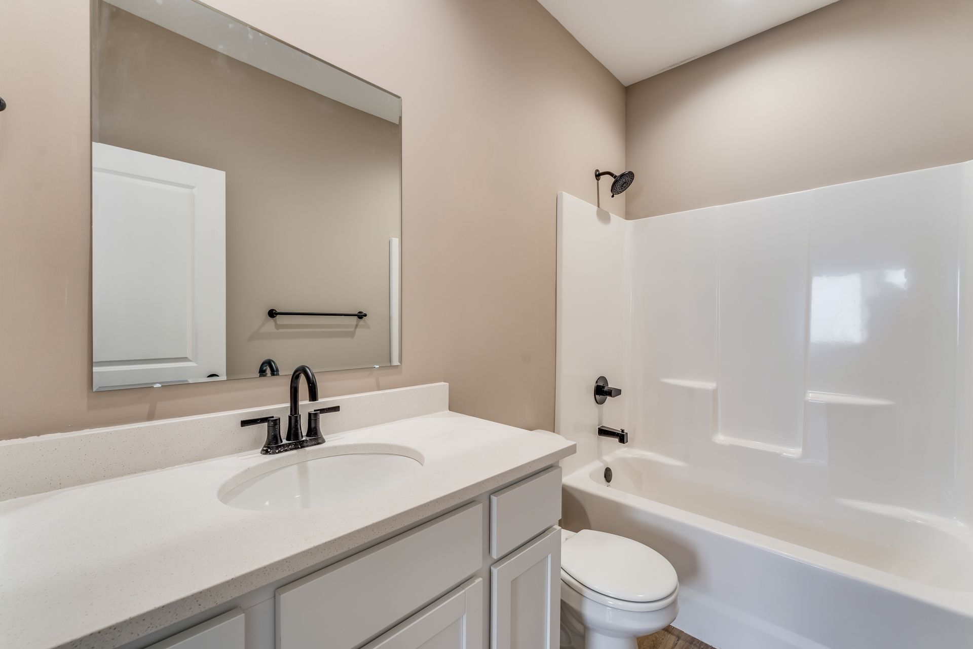 A bathroom with a sink , toilet , bathtub and mirror.