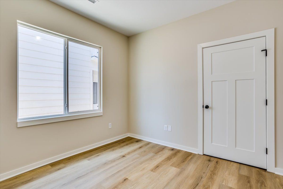 An empty room with a window and a door.