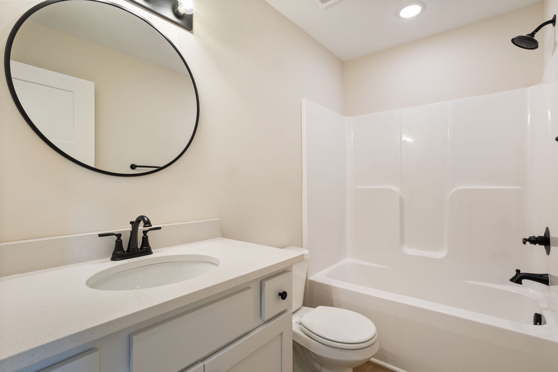 A bathroom with a sink , toilet , shower and mirror.