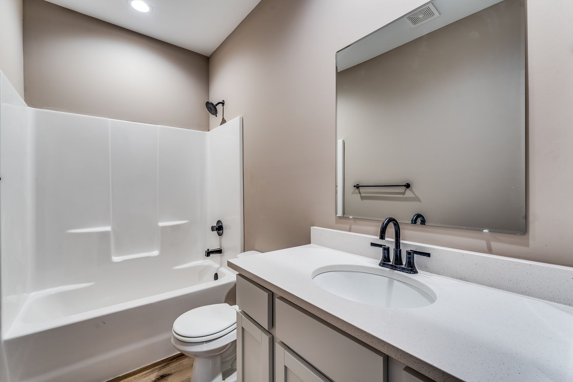 A bathroom with a sink , toilet , bathtub and mirror.