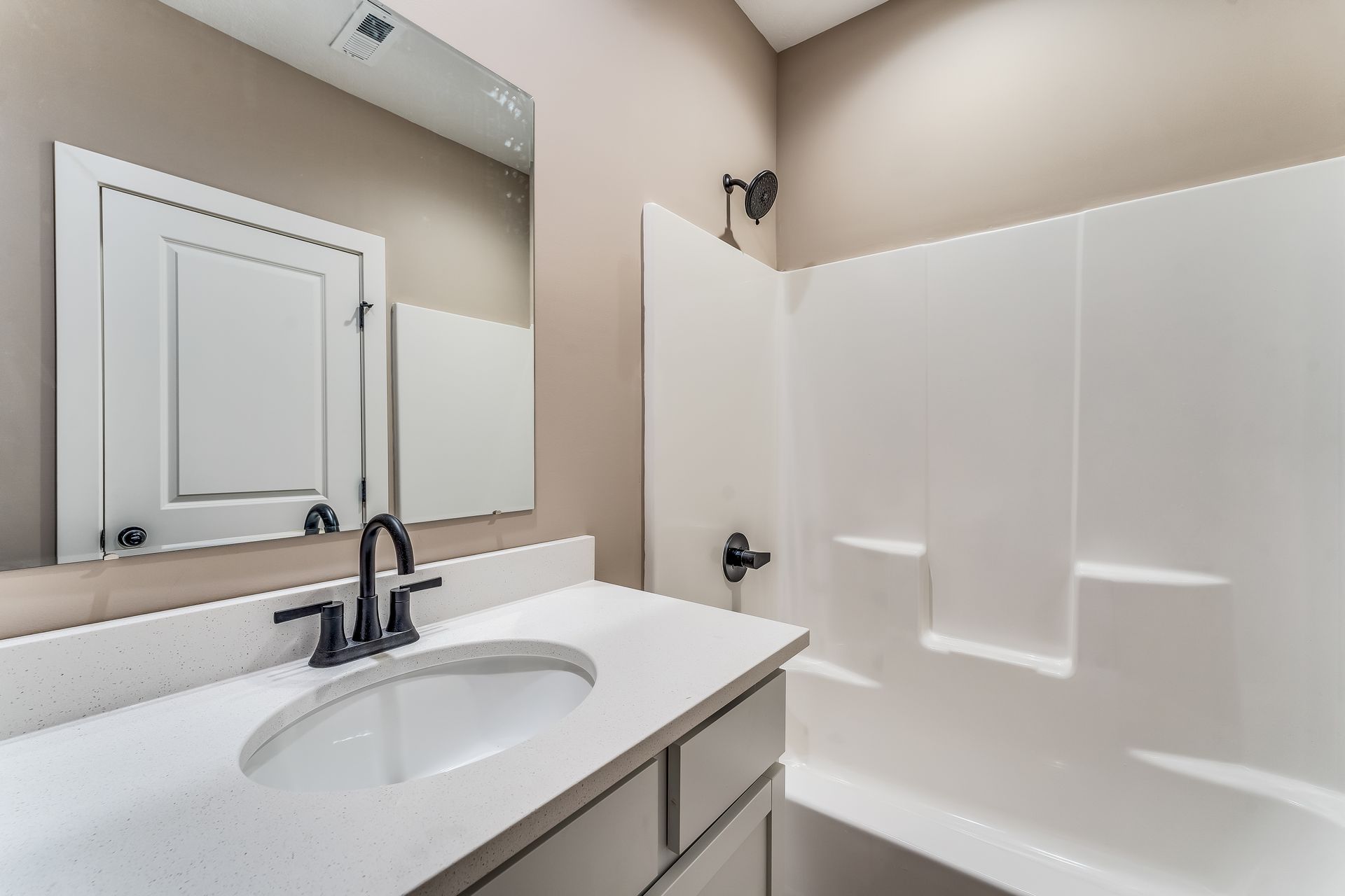 A bathroom with a sink , mirror and bathtub.