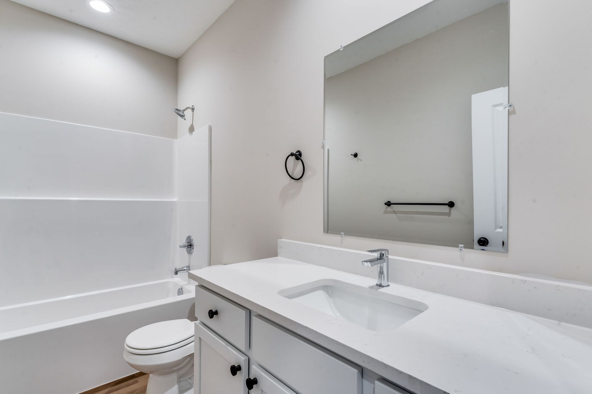 A bathroom with a toilet , sink , and mirror.
