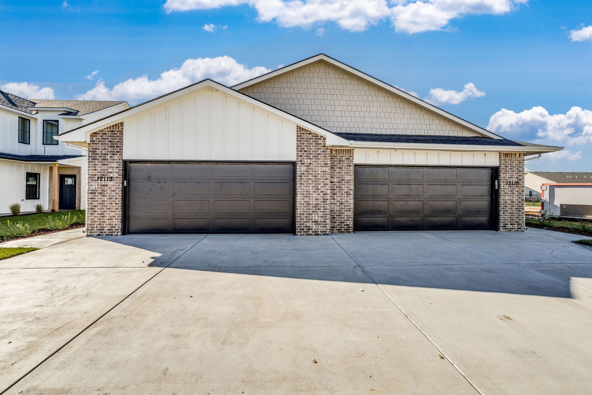 The front of a house with two garage doors and a driveway.