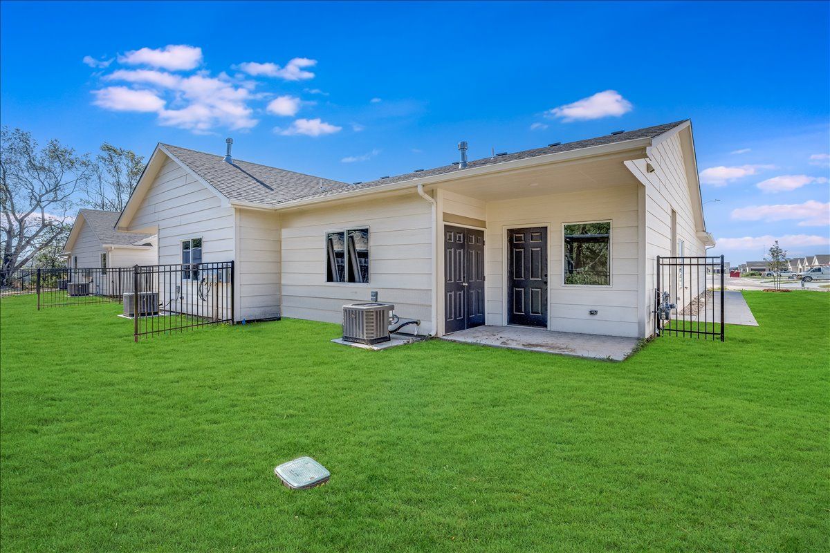 The back of a house with a large lawn in front of it.